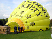 A hot air balloon is partially inflated with cold air from a petrol-driven fan, before the propane burners are used for final inflation.