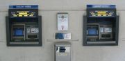 Two NCR Personas 84 ATMs at a bank in Jersey dispensing two types of pound sterling banknotes: Bank of England notes, and States of Jersey notes.