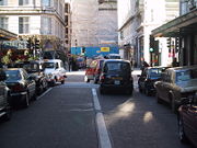Traffic driving on the right in Savoy Court in London (the UK usually drives on the left)