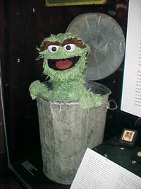 An Oscar the Grouch puppet (shown) and Sesame Street sign both reside in the Smithsonian National Museum of American History