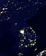 A satellite photo of the Korean Peninsula at night (the largest patch locates Seoul) illustrates large differences in outdoor illumination between North Korea and its neighbours.