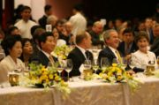 Putin (center) at the 2006 APEC gala dinner with Roh Moo-hyun, Kwon Yang-sook, George W. Bush (right), and Laura Bush (far right)