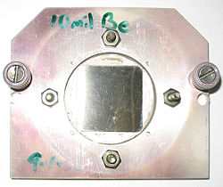 A square beryllium foil mounted in a steel case to be used as a window between a vacuum chamber and an X-ray microscope. Beryllium, due to its low Z number is highly transparent to X-rays.