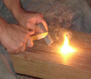 Magnesium firestarter (in left hand), used with a pocket knife and flint to create sparks which ignite the shavings