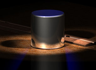 Shown above is a computer-generated image of the International Prototype Kilogram (“IPK”). The IPK is the kilogram. It sits next to an inch-based ruler for scale. The IPK is made of a platinum-iridium alloy and is stored in a vault at the BIPM in Sèvres, France. For other kilogram-related images, see Links to photographs, below.