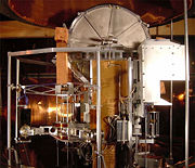 The NIST’s watt balance is a project of the U.S. Government to develop an “electronic kilogram.” The vacuum chamber dome, which lowers over the entire apparatus, is visible at top.