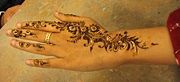 Mehndi is applied on women's hands at a Diwali Mela.