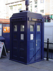 Police box mounted with a modern surveillance camera outside Earl's Court tube station in London.