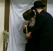 Grand Rabbi Israel Abraham Portugal of Skulen Hasidism lighting Hanukkah lights