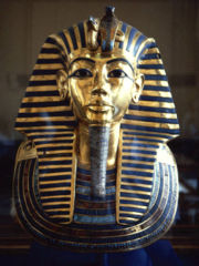 The iconic gold burial mask of Tutankhamun, inlaid with turquoise, lapis lazuli, carnelian and coloured glass.