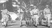 Lieutenant-General Percival led by a Japanese officer, marches under a flag of truce to negotiate the capitulation of Allied forces in Singapore, on 15 February 1942. It was the largest surrender of British-led forces in history.
