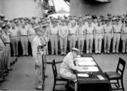 The signing of the Japanese surrender; MacArthur (sitting), behind him are Generals Percival and Wainwright.
