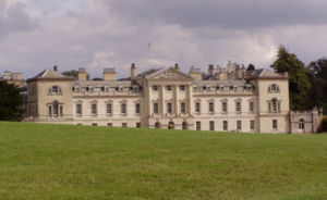 English Palladianism. Woburn Abbey, designed by Burlington's student Henry Flitcroft in 1746. Palladio's central temple is no longer free standing, the wings are now elevated to near equal importance, and the cattle sheds terminating Palladio's design are now clearly part of the facade.