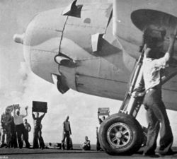 As a TBF Avenger prepares to take off from Enterprise on October 26, the signs held aloft by deck crewmen give the last known location of the Japanese carriers as well as instructions to proceed without waiting for Hornet’s aircraft.
