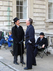 Actors in period costume sharing a joke whilst waiting between takes during location filming.