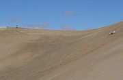 A tourist sliding down Star Dune in the Mesquite Flat Dune field.