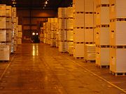 Inside Nexus Distribution, a United States-based logistics provider. Image shows goods stacked on pallets with forklift.