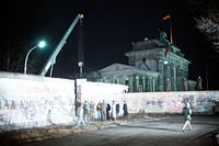 A crane lifting out a chunk of the Berlin Wall, December 1989