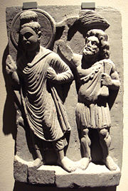 Gautama Buddha with his protector Vajrapani (here holding a flywisk). Gandhara, 2nd century CE.
