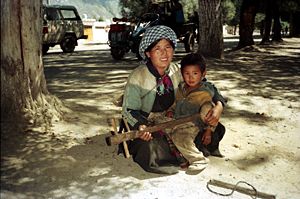 Woman with son busking in Lhasa, 1993.