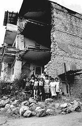Armenian children standing next to the rubble of a building in Stepanakert after a shelling barrage.