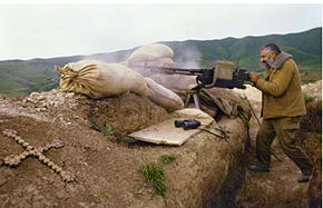 An Armenian fighter firing an NSV heavy machine gun, often found on tank turrets, in a trench in Hadrut in the summer of 1992.