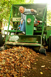 A Hazelnut farmer inspects the row for unwanted debris as he drives over it with the harvester