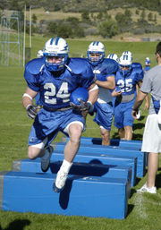 A halfback leads fellow backs through an agility drill at the Air Force Academy