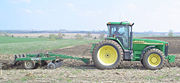 A modern John Deere 8110 Farm Tractor using a chisel plough.