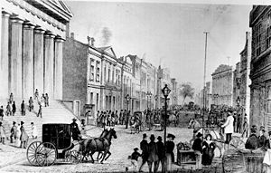 View in Wall Street from corner of Broad Street, 1867. The building on the left was the U.S. Customs House at the time but is today the Federal Hall National Memorial.