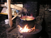 Ancient Swiss way of making cheese (heating stage). If needed, the wooden holder can be turned, moving the pot away from fire