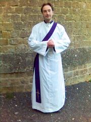 An Anglican deacon wearing a purple stole over his left shoulder.