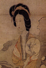 Appreciating Plums, by Chen Hongshou (1598 - 1652) showing a lady holding an oval fan whilst enjoying the beauty of the plum.