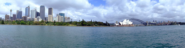 A panorama of Sydney Harbour during the day, with the Sydney Opera House on the right and Sydney Harbour Bridge in the background, the Royal Botanic Gardens and the central business district are to the left