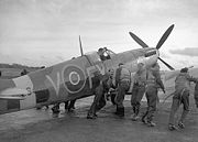 Pilots of 611 West Lancashire Squadron lend a hand pushing an early Spitfire Mark IXb, Biggin Hill, late 1942. (RAF Official)