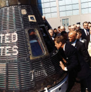 President Kennedy looks at the spacecraft Friendship 7, which made three earth orbits piloted by astronaut John Glenn, February 23, 1962, Cape Canaveral, Florida