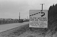 This sign, photographed in 1941 on the main highway between Seattle and Portland, illustrates the original rationale for a federal highway system: national defense.