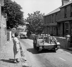 Universal Carriers of the 9th King's moving through a Sussex village, 3 July 1941.