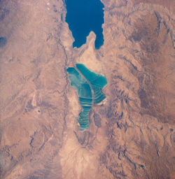 View of salt evaporation pans on the Dead Sea, taken in 1989 from the Space Shuttle Columbia. The southern half is now separated from the northern half at what used to be the Lisan Peninsula because of the fall of the level of Dead Sea.