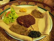 Typical Ethiopian cuisine: Injera (pancake-like bread) and several kinds of wat (stew).