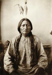 Sitting Bull adorned with eagle feathers