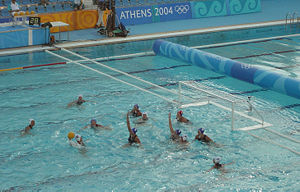 A classic 4-2 man-up situation.  The attacking white team has 4 players positioned on 2 metres, and 2 players positioned on 4 metres.  The 5 outfield defending blue players try to block shots and prevent a goal being scored for the 20 seconds of man-down play.  In the top left corner, the shot clock can be seen, showing 28 seconds remaining in the white attack.