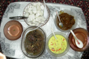 Typical festive fare during Hari Raya Puasa or Hari Raya Haji (clockwise from bottom left): beef soup, ketupat (compressed rice cubes), beef rendang and sayur lodeh.