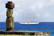 Moai with replica eyes at Ahu Ko Te Riku in Hanga Roa, with Chilean Navy ship Buque Escuela Esmeralda behind.