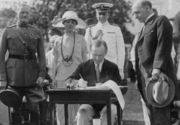 Coolidge signing the Immigration Act and some appropriation bills. General John J. Pershing looks on.