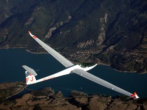A single-seat high performance fiberglass Glaser-Dirks DG-808 over the Lac de Serre Ponçon in the French Alps