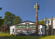 A Kwakwaka'wakw totem pole and traditional "big house" in Victoria, British Columbia.
