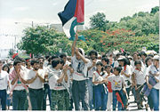 Palestinian Nicaraguans celebrating the 10th anniversary of the Nicaraguan revolution in Managua waving Palestinian and Sandinista flags.
