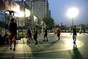 Evening pickup basketball game in a Beijing neighborhood.