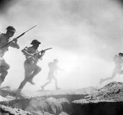 Infantry advance during the Battle of El Alamein. In fact, this image was staged by the photographer Len Chetwyn, and shows Australians storming their own cookhouse.